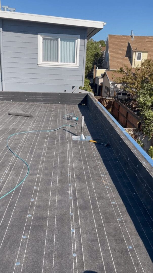 Flat rooftop with tools and equipment visible.